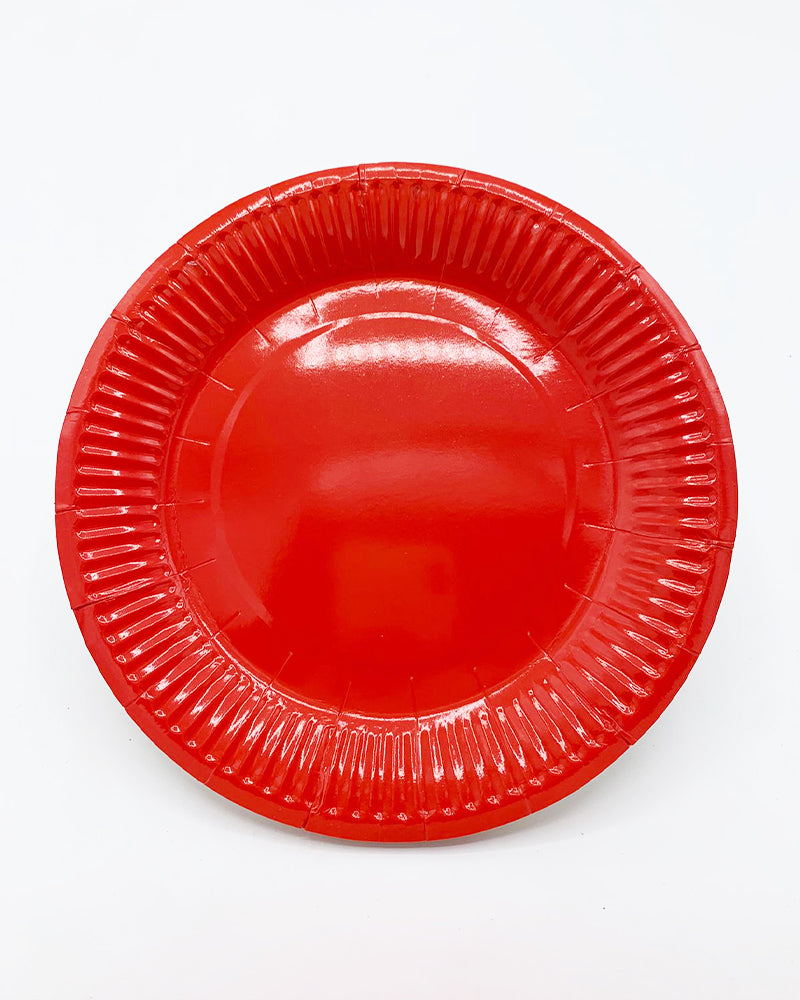 Dix assiettes rouges à bord nervuré pour table de fête